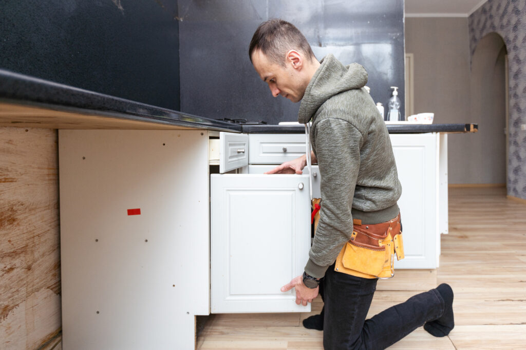 Un homme qui est en train de désassambler sa cuisine pour demenager